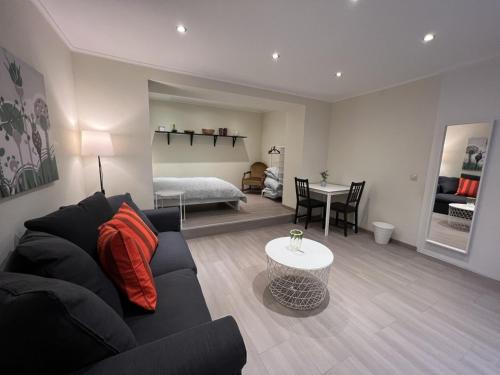 ein Wohnzimmer mit einem schwarzen Sofa und einem Tisch in der Unterkunft city rooms luxembourg in Luxemburg (Stadt)