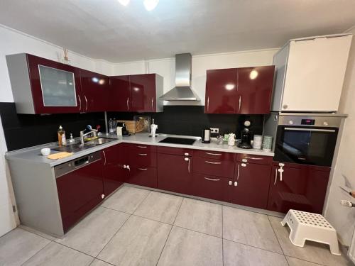 uma cozinha com armários vermelhos e um lavatório em city rooms luxembourg no Luxemburgo