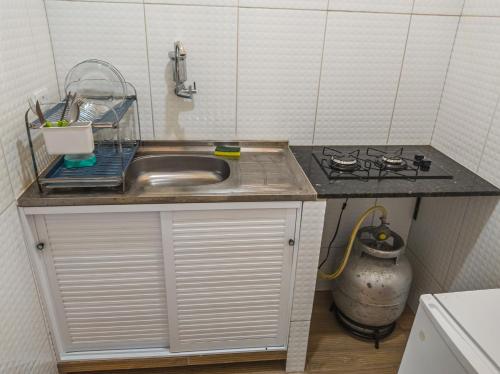 a small kitchen with a sink and a stove at casa morada da praia in Xeréu