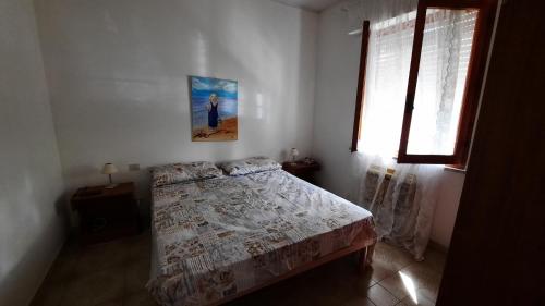 プリンチピナ・ア・マーレにあるA casa di Lauraのベッドルーム1室(ベッド1台付)が備わります。壁に絵が飾られています。