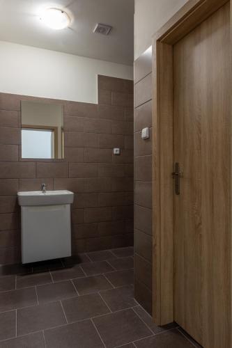 a bathroom with a toilet and a wooden door at Apartmány SKI KRASLICE - NOVĚ OTEVŘENO in Kraslice