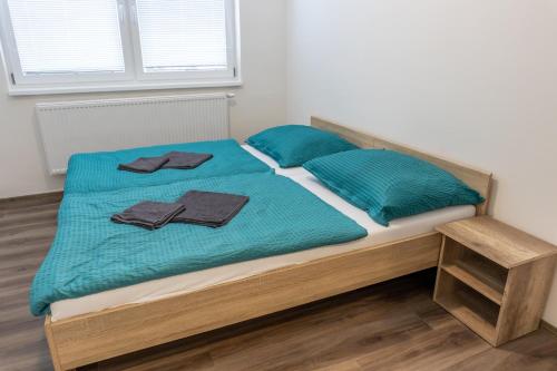 a bed with two blue pillows on top of it at Apartmány SKI KRASLICE - NOVĚ OTEVŘENO in Kraslice