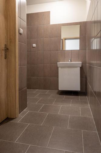 a bathroom with a sink and a tiled floor at Apartmány SKI KRASLICE - NOVĚ OTEVŘENO in Kraslice