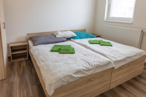 a bed with two green towels on top of it at Apartmány SKI KRASLICE - NOVĚ OTEVŘENO in Kraslice