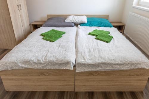 a bed with white sheets and green towels on it at Apartmány SKI KRASLICE - NOVĚ OTEVŘENO in Kraslice