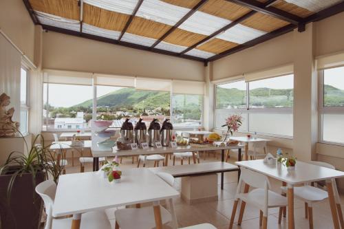 a restaurant with tables and chairs and windows at Hotel Tonight in Salta