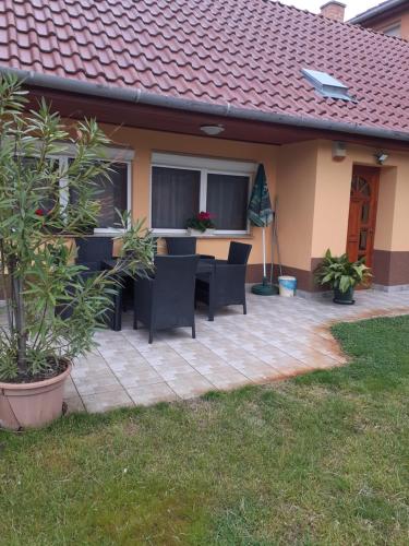 a patio with chairs and a table in a house at Szahara Vendégház in Kerekegyháza