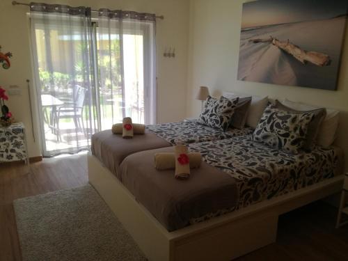 a bedroom with two beds and a balcony at Apartamento luxo e sossego in Albufeira