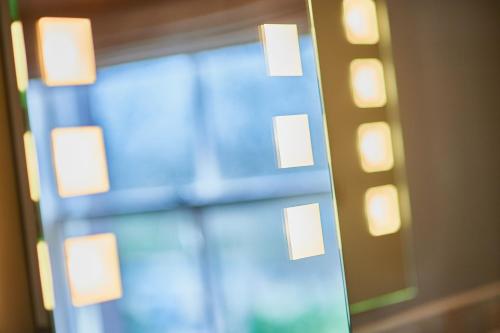 a mirror with lights on the side of a wall at The Parklands Hotel in Perth