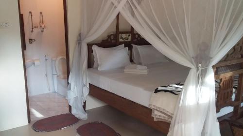 a bedroom with a bed with a canopy at Safina Resort in Zanzibar City