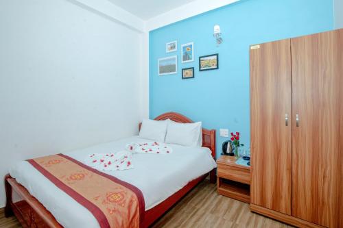 a bedroom with a bed and a wooden cabinet at Moc Nhien Hostel Da Lat in Da Lat
