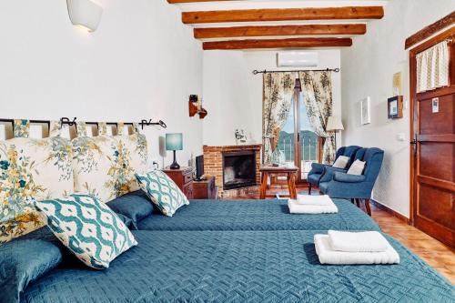 a bedroom with a large bed with blue sheets and a fireplace at Los Huertos de Segura in Segura de la Sierra