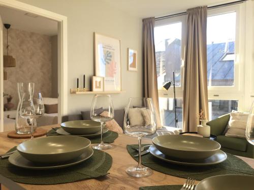 a dining room table with plates and wine glasses at Joya en Orense Centro in Ourense