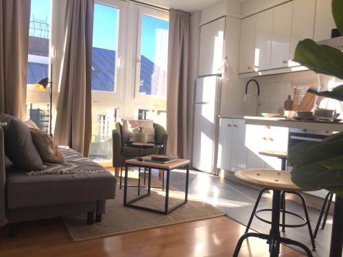 a living room with a couch and a kitchen at Joya en Orense Centro in Ourense