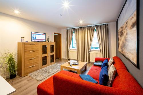 a living room with a red couch and a tv at Bördeapartment 1 in Vahldorf