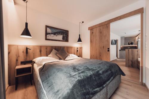a bedroom with a large bed and wooden walls at Alpenheim Apartment Ischgl in Ischgl