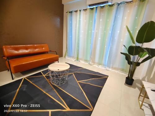 an orange chair and a table in a room at PavilionVillie Ipoh in Kampong Sengat