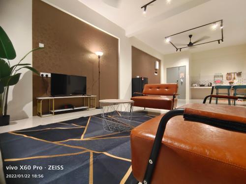 a living room with a flat screen tv and a couch at PavilionVillie Ipoh in Kampong Sengat