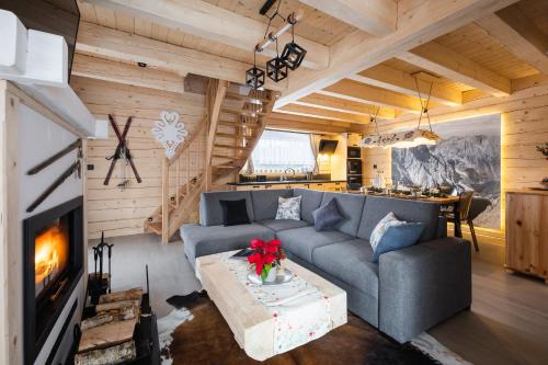 a living room with a couch and a fireplace at Osada Chłabówka Zakopane & SPA in Zakopane