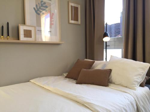 a white bed with two pillows on top of it at Joya en Orense Centro in Ourense
