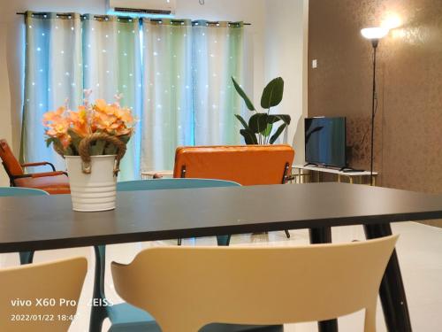 a table with chairs and a vase with flowers on it at PavilionVillie Ipoh in Kampong Sengat