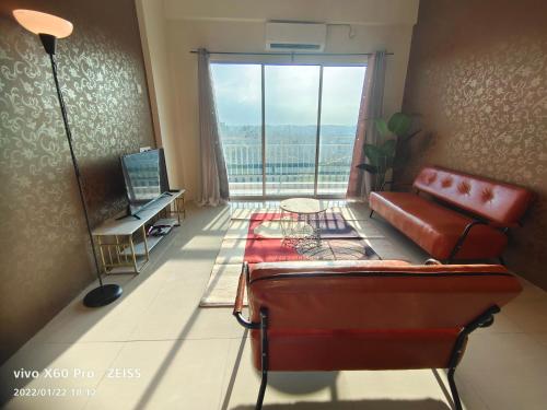 a living room with a couch and a large window at PavilionVillie Ipoh in Kampong Sengat