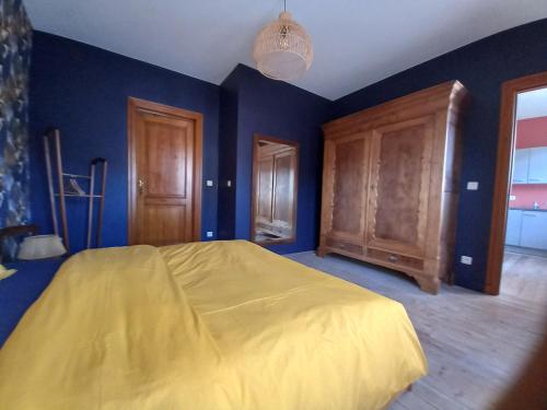a blue bedroom with a bed and wooden cabinets at Le vieux Spa de Polo-Jo in Spa