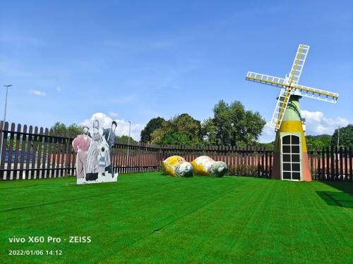 a yard with a fence and a windmill and balls at PavilionVillie Ipoh in Kampong Sengat
