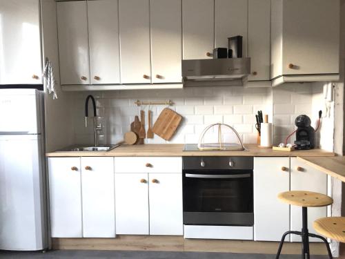 a kitchen with white cabinets and a black oven at Joya en Orense Centro in Ourense