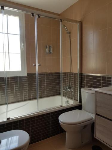 een badkamer met een douche, een toilet en een wastafel bij Apartments Sol de Almeria Golf y Playa II in Almería