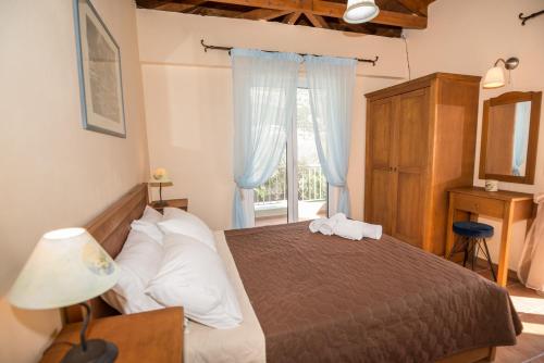 Un dormitorio con una cama con dos toallas encima. en Vasilikos -Green Poros Village, en Mikros Gialos