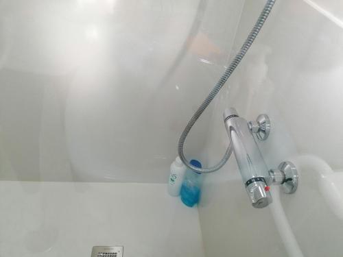 a bath tub with a shower head in a bathroom at Casa IRIENSE VUT-CO-004308 in Padrón