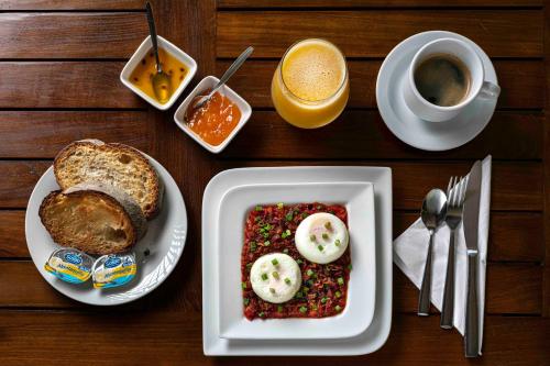 a table with a plate of food and a cup of coffee at Hotel Villa Colonial in Santo Domingo