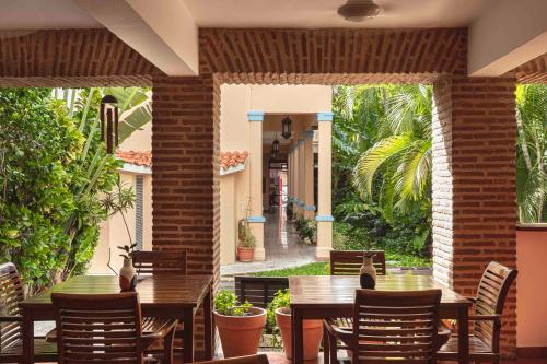 a dining room table with chairs and umbrellas at Hotel Villa Colonial in Santo Domingo
