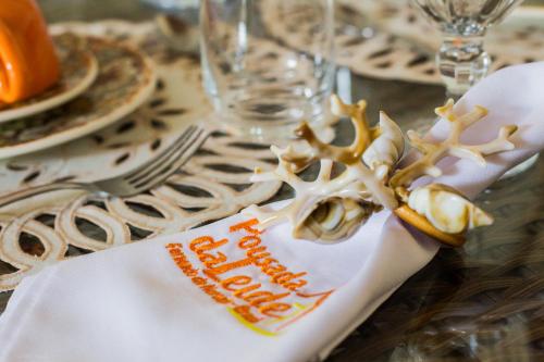 a table topped with a white napkin with a reindeer napkin at Pousada da Leide in Fernando de Noronha