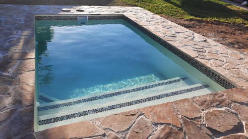 a swimming pool with a stone path around it at Denmark Farm Stay in Cradock