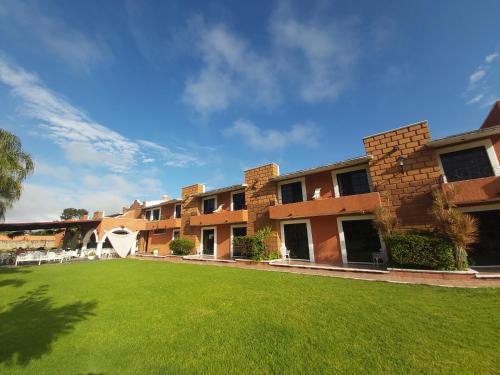 AcámbaroにあるHotel Meson del Puenteの建物前の空芝生