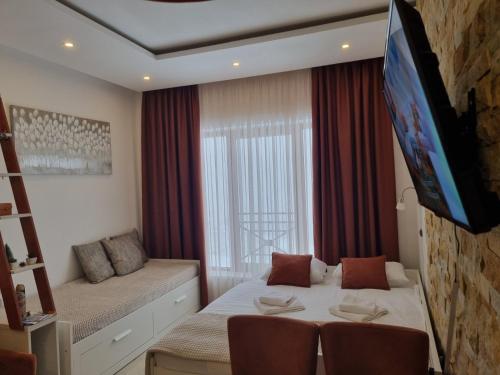1 dormitorio con 1 cama y TV en la pared en Milmari Apartman P38 en Kopaonik