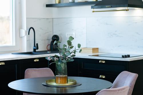 a kitchen with a table with a vase of flowers on it at Villa Artemis in Plitvička Jezera