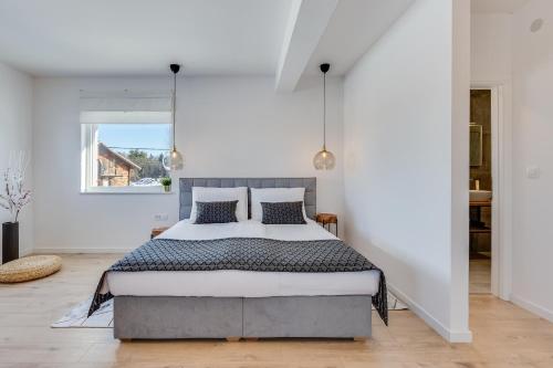 a bedroom with a large bed in a white room at Villa Artemis in Plitvička Jezera