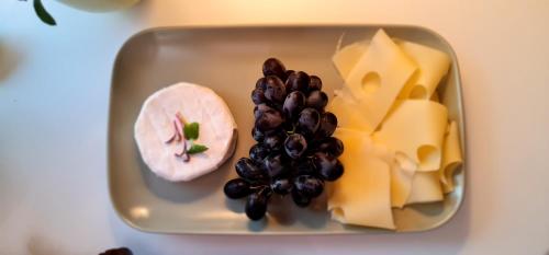 a tray with cheese and grapes and cheese and cheese and meat at Mont Blanc Chalet in Grandevent