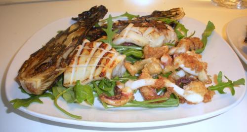 a plate of food with fish and vegetables on a table at Casa vacanze La Meridiana in Donnalucata