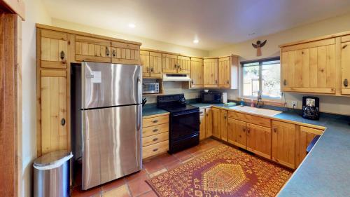 a kitchen with wooden cabinets and a stainless steel refrigerator at Arena Roja #2279 in Moab