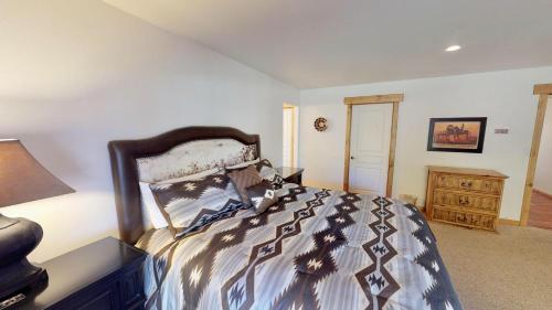 a bedroom with a bed and a table with a lamp at Arena Roja #2279 in Moab