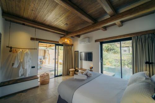 a bedroom with a large bed and a large window at Hide Out Villas in Mylopotas