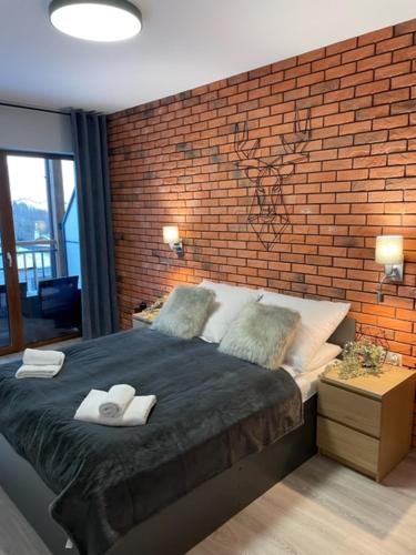 a bedroom with a brick wall and a bed at Apartament Silence Karpatia Resort Koral in Karpacz