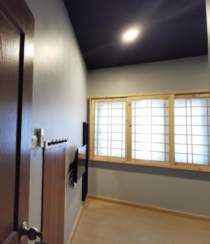 a hallway with a door and two windows at Tatami D'Tepi Laut - PANGKOR ISLAND in Pangkor