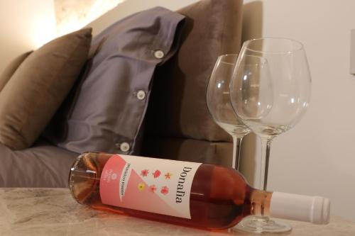a bottle of wine sitting next to a wine glass at MATTEI LUXURY B&B in Altamura