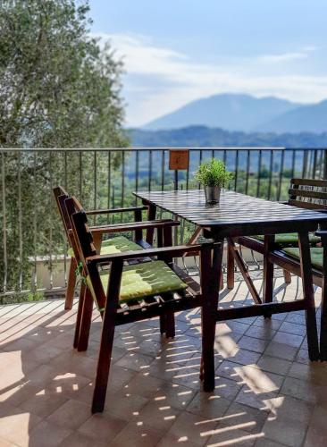 a wooden table and benches on a deck with a view at Casa Elisabetta ShortLets in Caposele