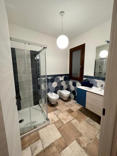 a bathroom with a shower and a toilet and a sink at HomeStyle Agorà in Villasimius